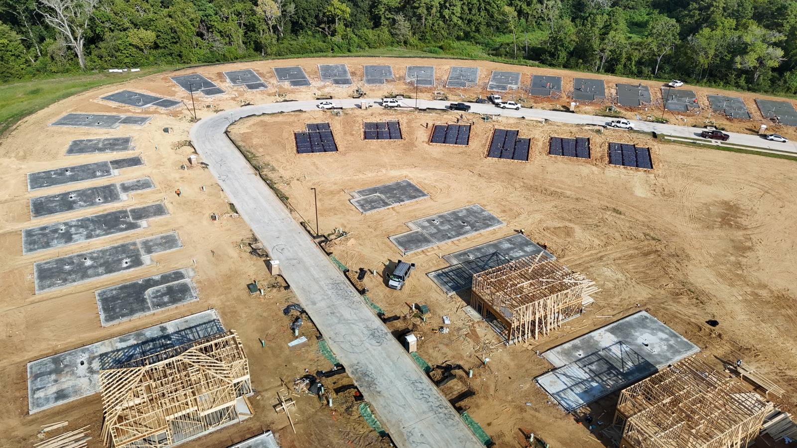 Curved street of residential slabs near Montgomery, with steel set, finished slabs and framing going up